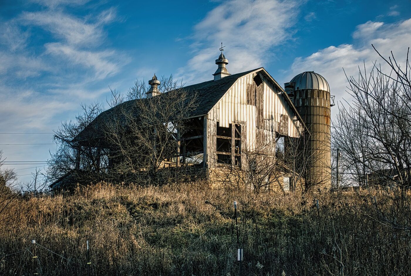 The Last Harvest, a heritage structure in managed decline, in open Upper Midwest farmland.